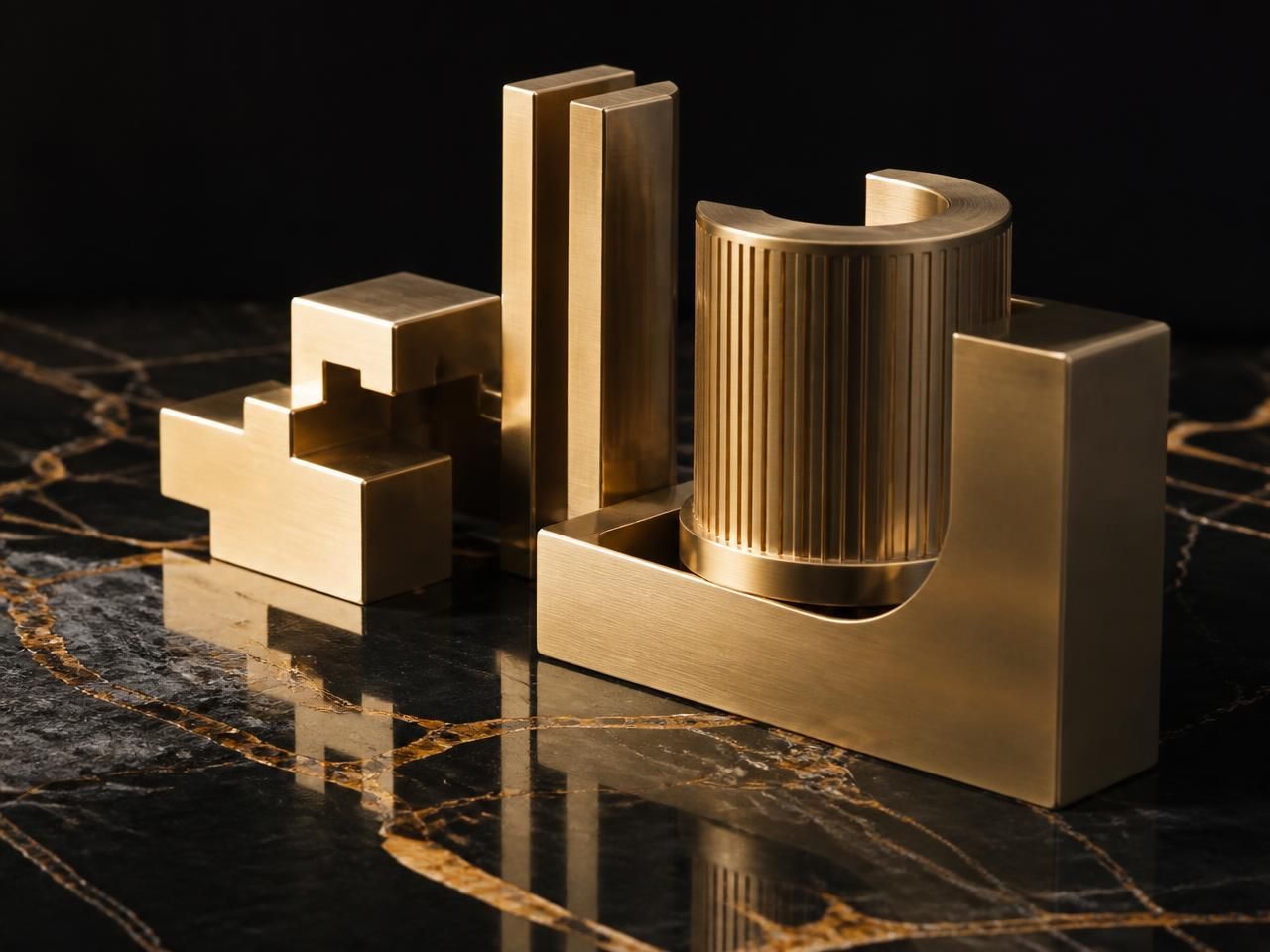 Precision-milled champagne gold forms on polished black marble